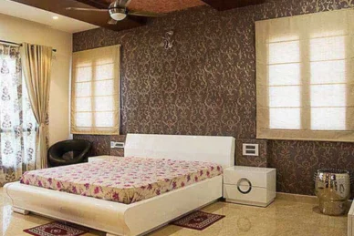 The cosy bedroom features a white bed and brown wallpaper implies warm lighting & beautiful decor.