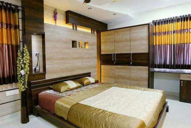 The interior of a bedroom with a golden hue bed & a cabinet unit creates a sumptuous atmosphere.