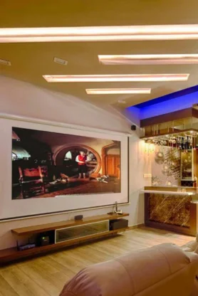 A contemporary home theater featuring a spacious screen, and glass walls gives a stunning look.