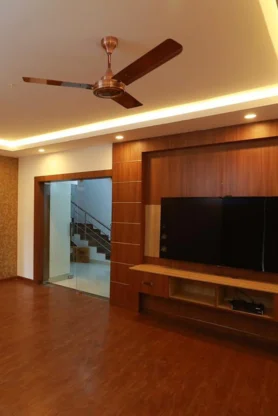 A ceiling fan on the inner screen side of a living room gives a visually stylish design.