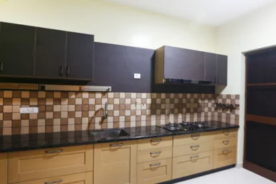 A kitchen with sleek black cabinets and warm brown tiles, creating a modern and inviting atmosphere.