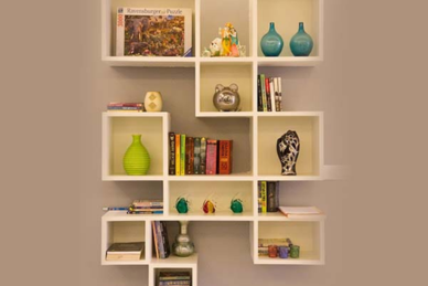 A white interior shelf displaying books and vases, adding a touch of elegance to the room's decor.