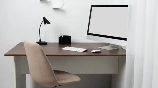 A useful environment for productivity that includes a keyboard and monitor on a computer desk