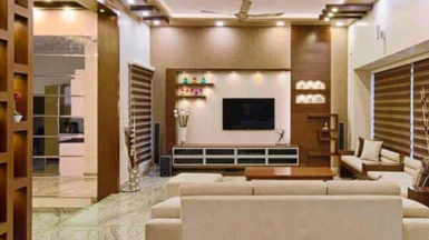 A beautiful living room with a television and soft sofas indicates a good interior design.