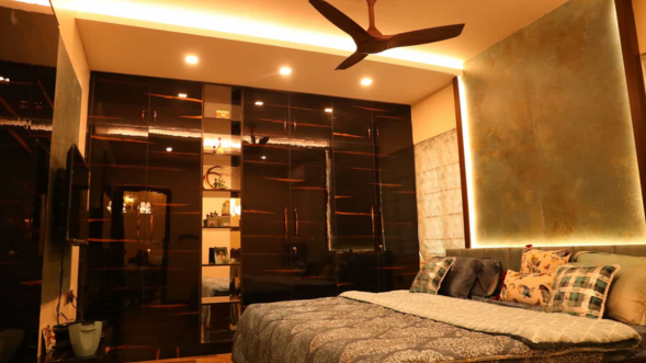 An appealing bedroom with a comfortable bed, a ceiling fan, a mirror, and wardrobes is featured.