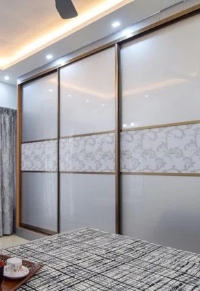 A designed effectively bedroom comprises a lovely mirror wardrobe, a fan, and a comfortable bed.