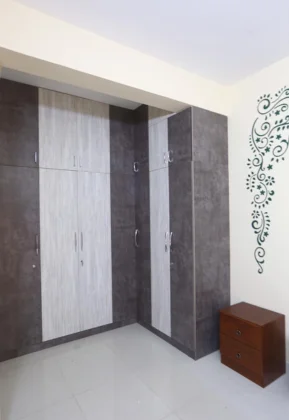 A modern room with a colourful mural and a black and white wooden wardrobe gives a rich look.