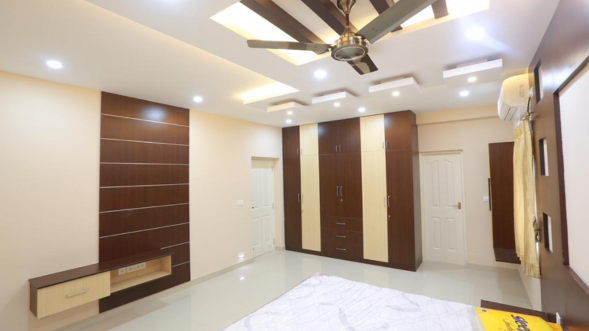 A huge bedroom with the best brown and beige wardrobe design creates the best interior design.